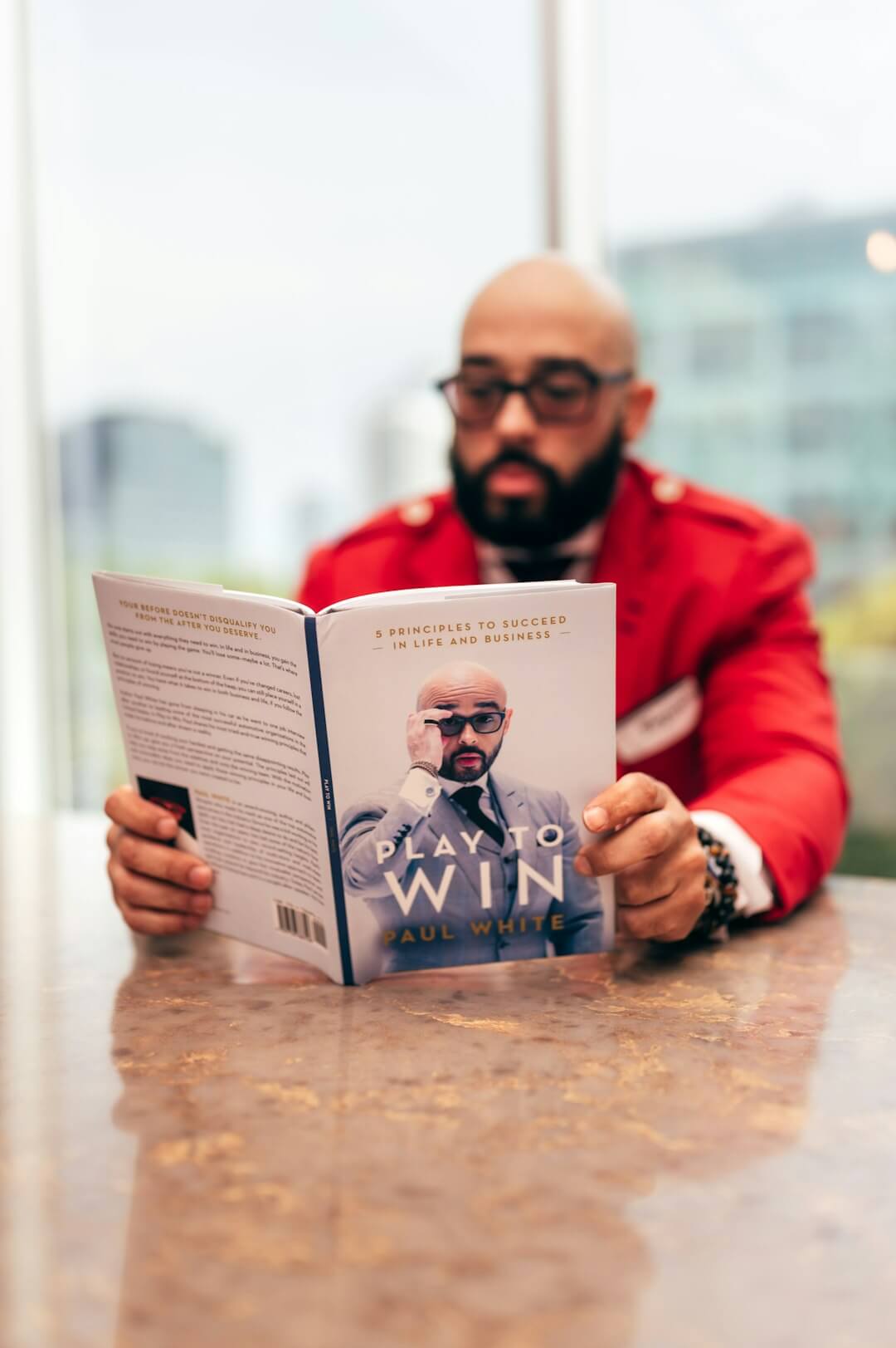 man in red jacket reading book